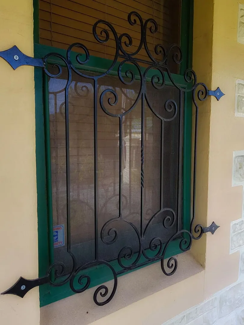 Decorative wrought iron security grille installed over a window