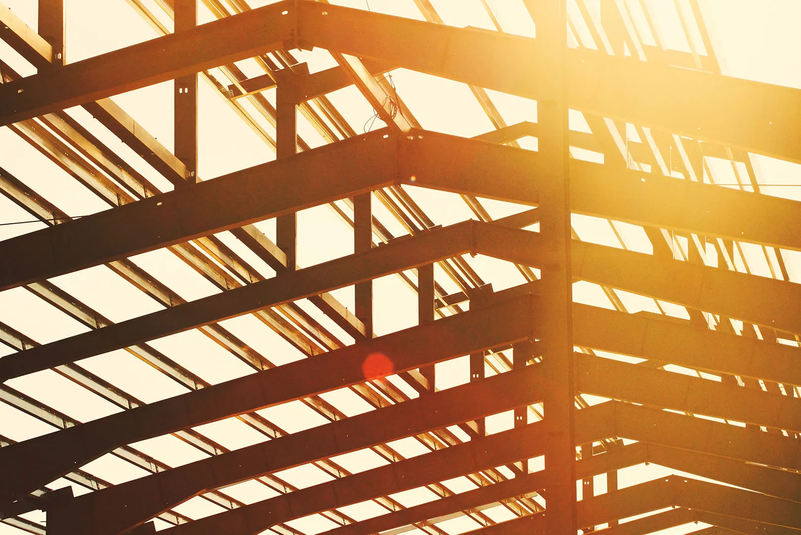 Structural steel roof framing illuminated by the afternoon sun